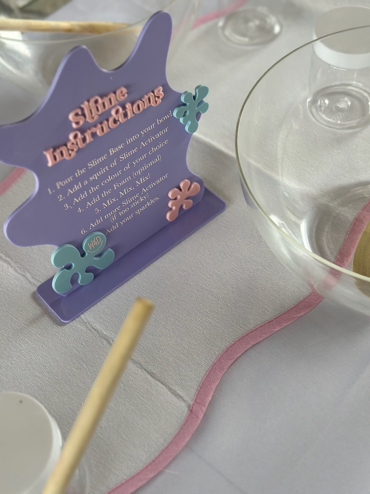 Styled slime-making station with instruction card for a Wonder & Dash Slime Workshop party